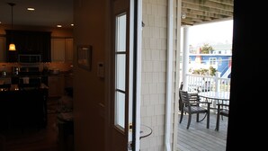 A view from a balcony with a wooden deck, a dining table, and chairs.