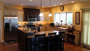 A modern kitchen with a central island, stainless steel appliances, and pendant lighting.