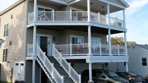 A two-story building with a balcony on the upper floor and a garage on the ground floor.