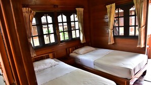 A wooden cabin room with two beds, a window with curtains, and a view of greenery outside. - Little Home Beach (Kui Buri)
