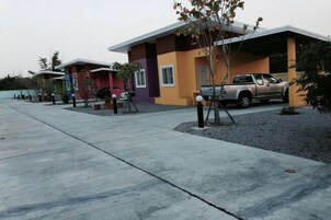 Una hilera de edificios residenciales modernos, de varios pisos, con un área de estacionamiento al frente.