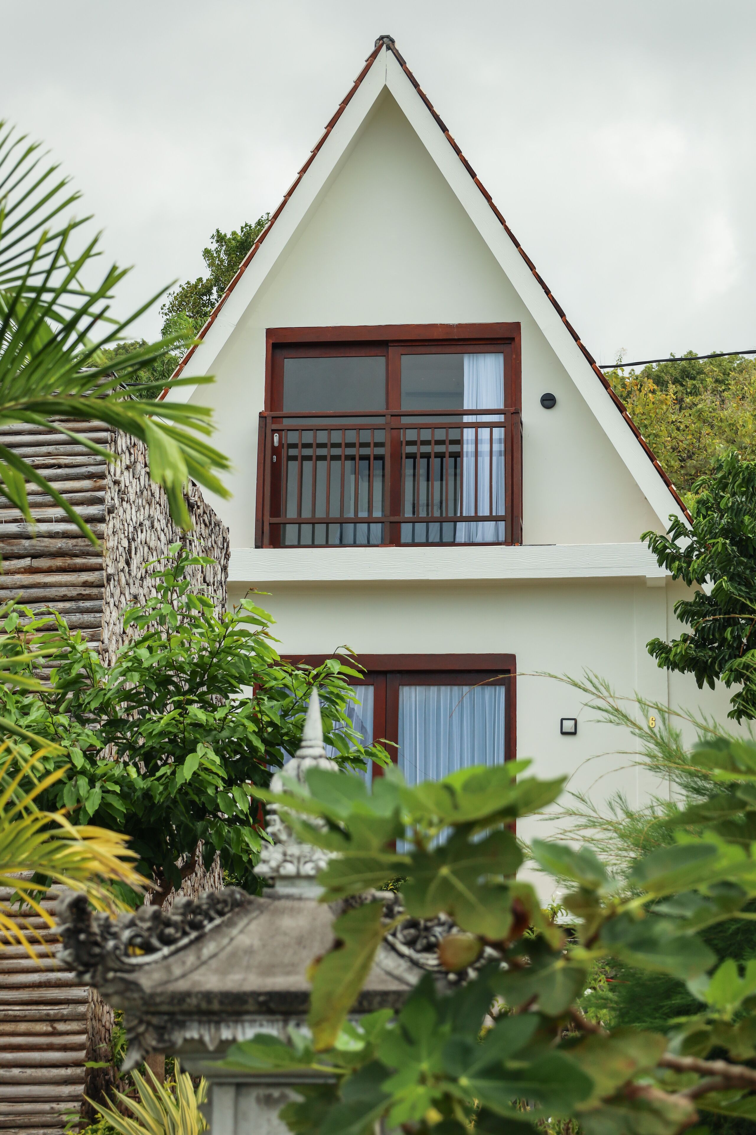 A two-story house with a white exterior and brown window frames.