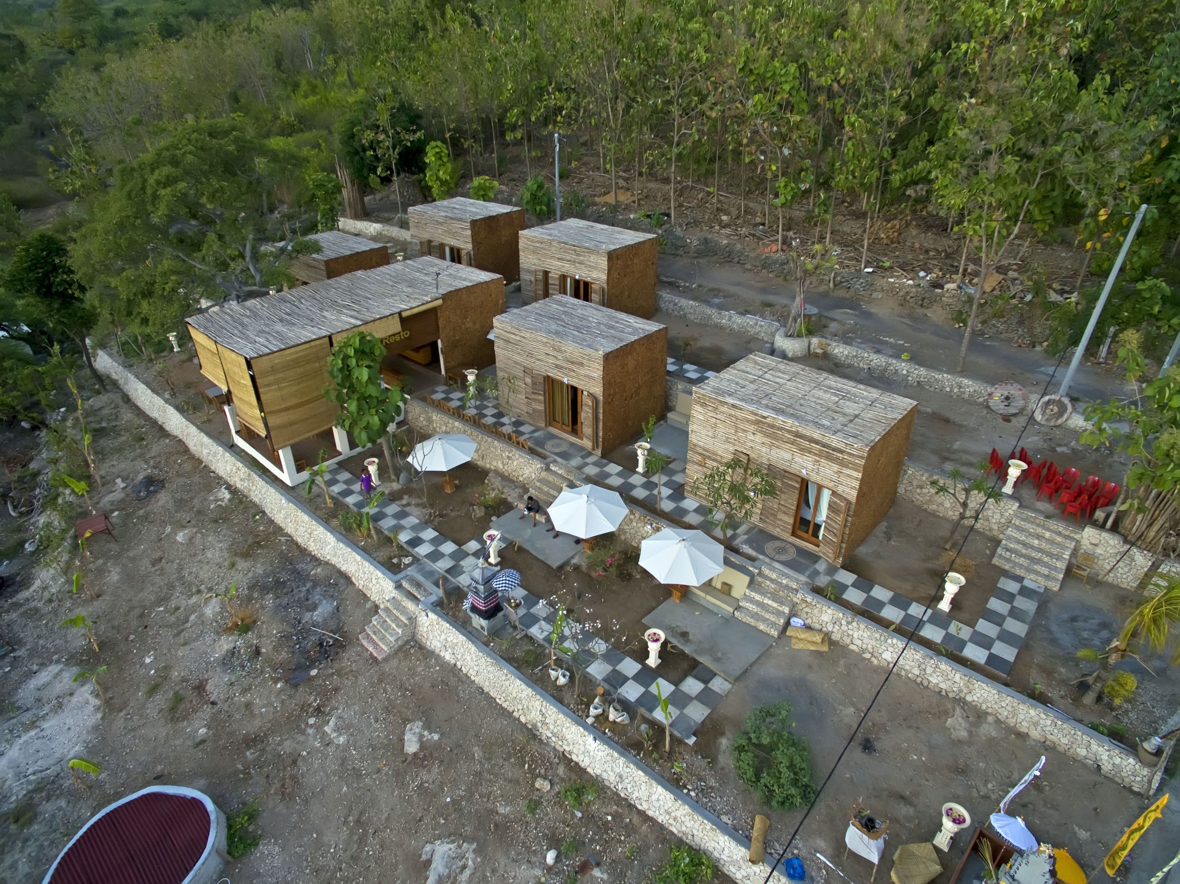 A model of a rustic-style building complex with multiple rooms, outdoor seating areas, and a stone pathway.