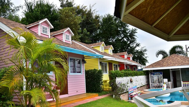 Una hilera de casas coloridas con una piscina al frente.