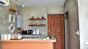 Una cocina compacta con mostrador de madera, una cafetera y diversos utensilios de cocina.