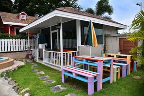 A covered outdoor area with colorful benches and a white picket fence. - Baan Tua Mor Resort (Pranburi)