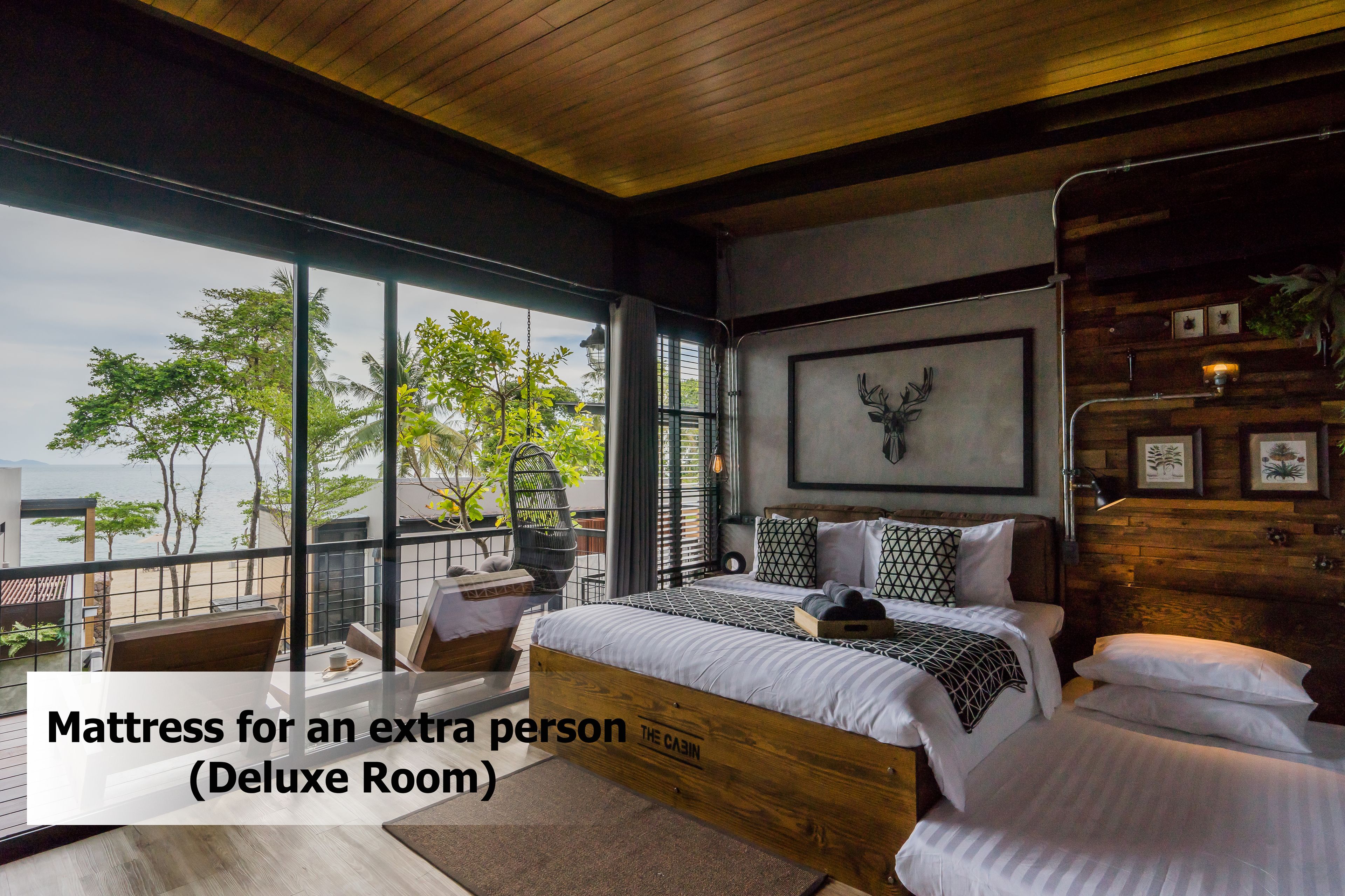 Una habitación de lujo con una cama grande, vistas al mar y techo de madera.