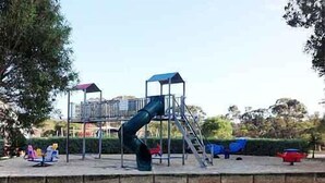 Um parquinho com escorrega e estruturas de escalada.