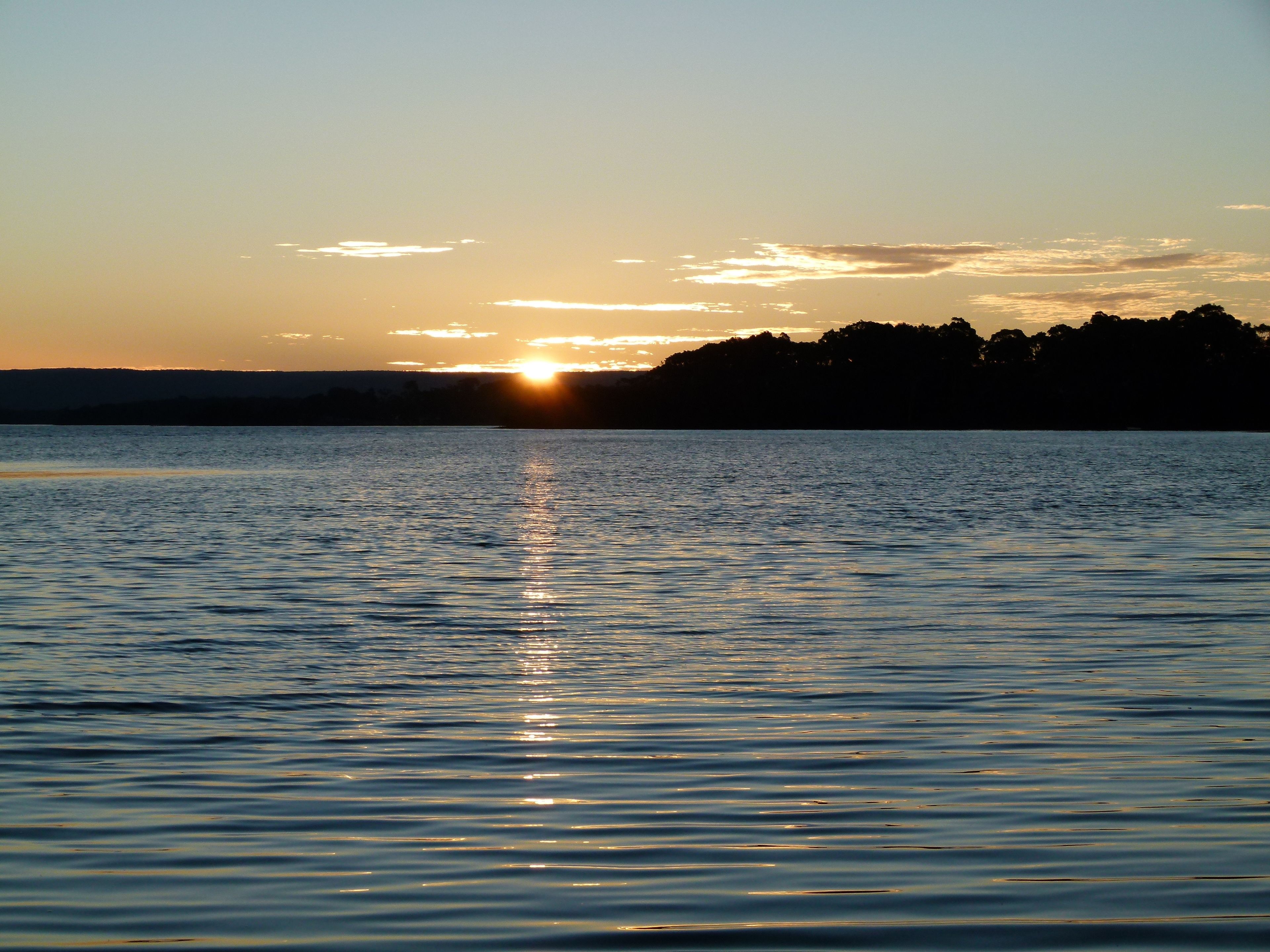 Une étendue d'eau calme où le soleil se reflète.