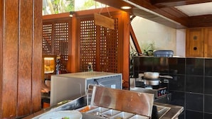 Disposição de buffet com vários recipientes de comida, um balcão e uma divisória de madeira.