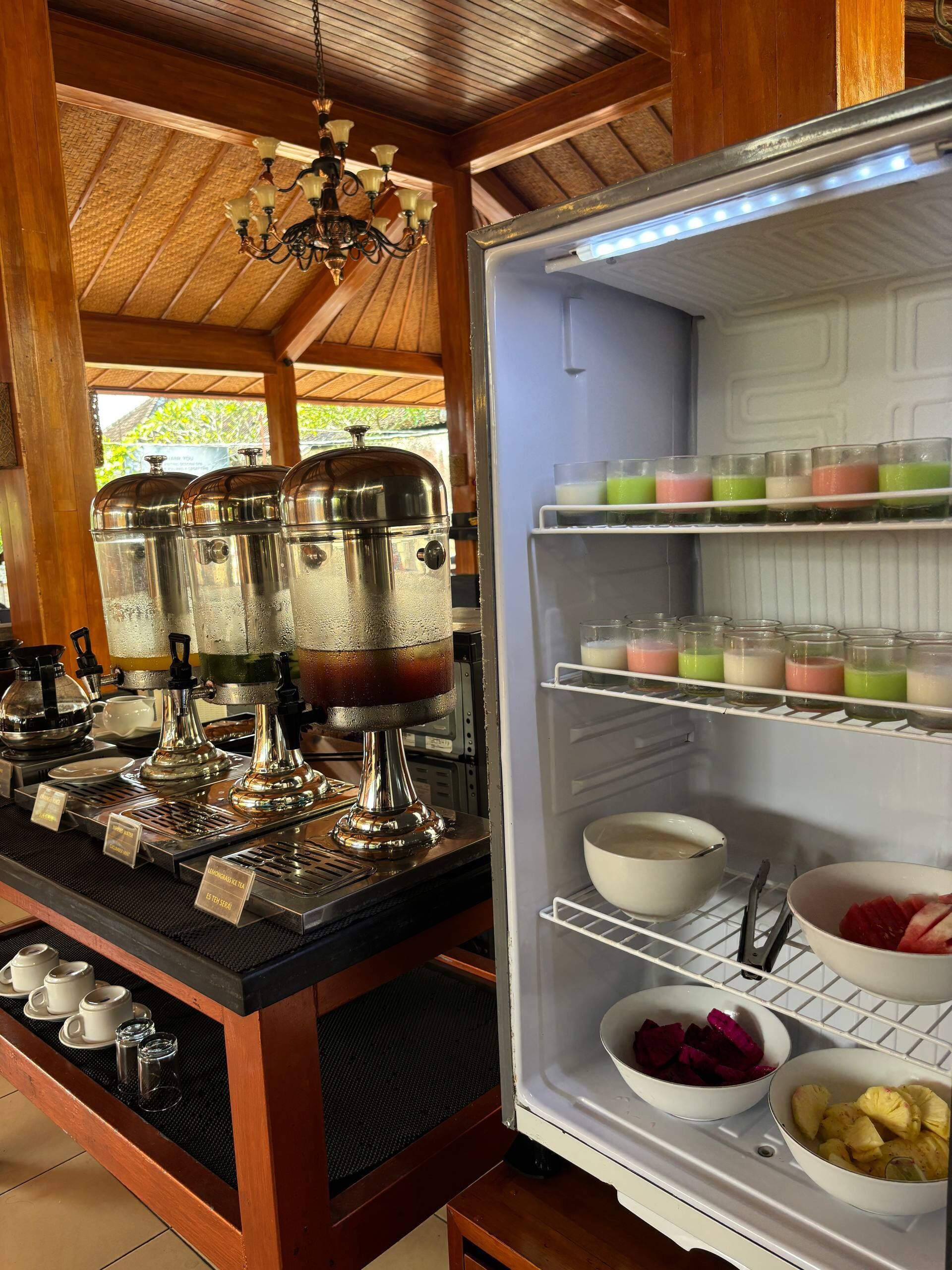 Eine Küchenzeile mit Kaffeemaschine, einem mit Getränken gefüllten Kühlschrank und einer Holzausstattung.