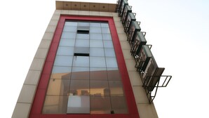Un edificio con una grande facciata vetrata e la scritta “Nirmal Mahal” ben visibile in basso.