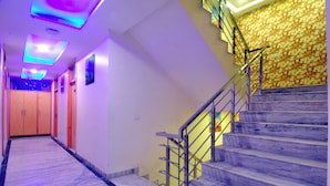 A modern interior with a marble staircase, a wooden door, and a patterned wall. - Check In Room New Delhi Railway Station (New Delhi)