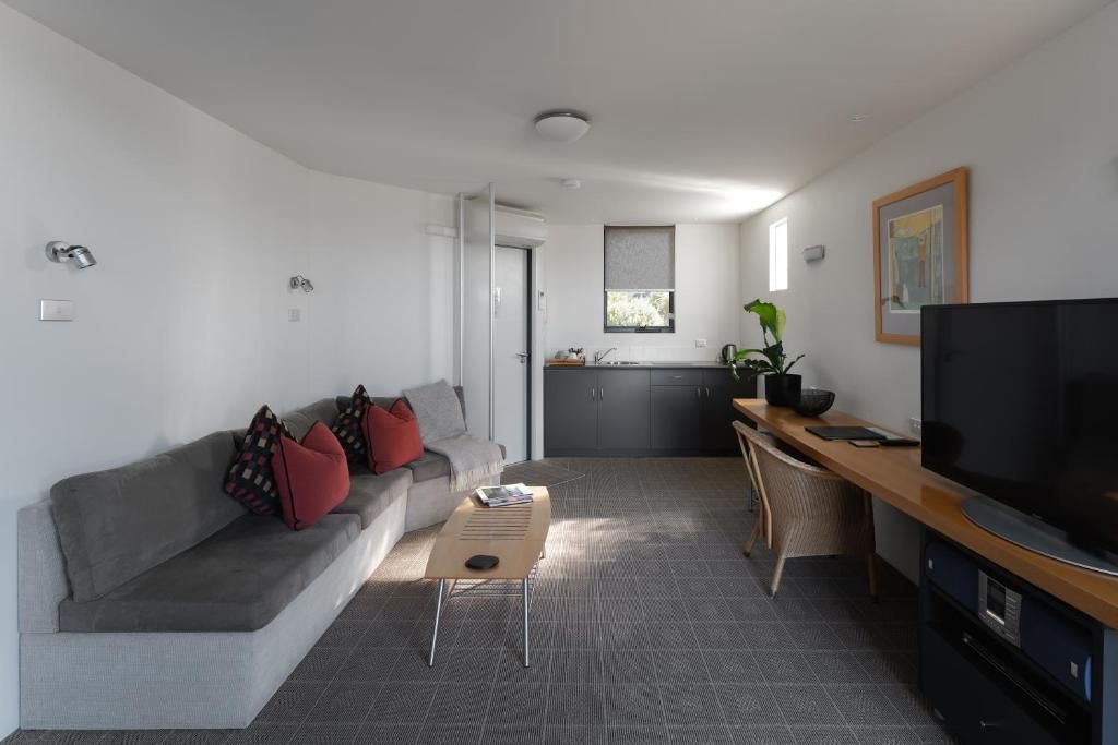 Een moderne woonkamer met een bank, salontafel en televisie.