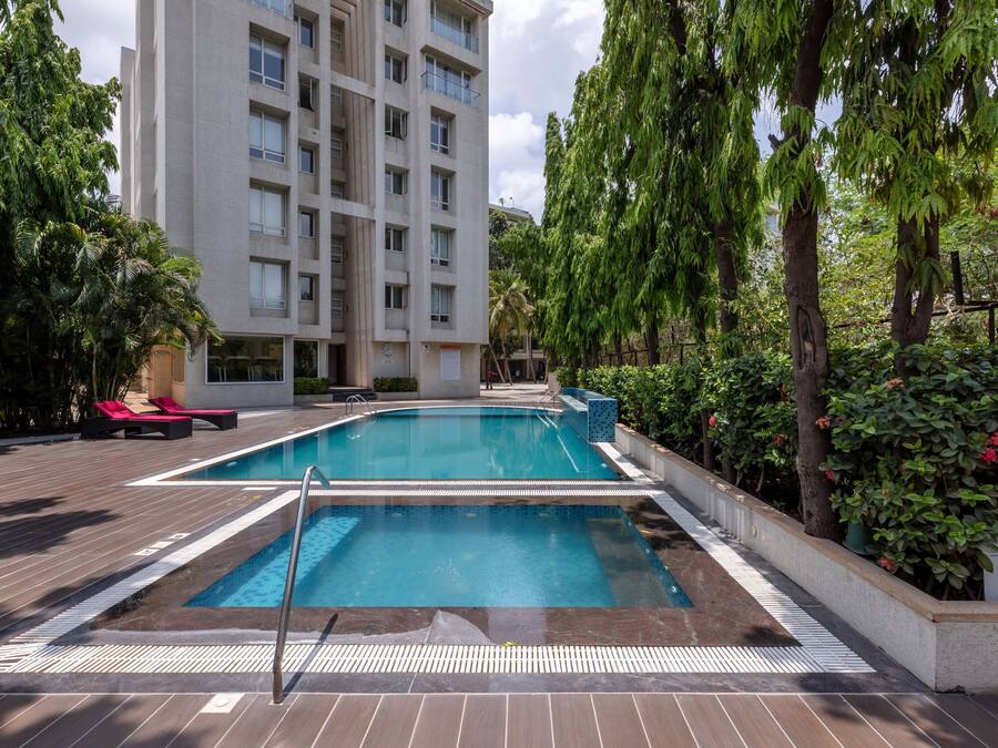 A swimming pool with lounge chairs and a building in the background.