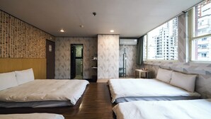A hotel room with two beds, a wooden floor, a patterned wall, and a window with a city view. - Sofu Hotel (New Taipei City)