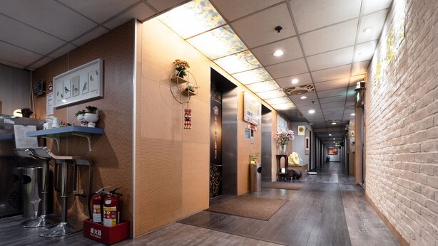 A hallway with a fire extinguisher, a fire hose, and a red box on the floor. - Sofu Hotel (New Taipei City)