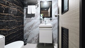 A bathroom with a marble wall, a white sink, and a mirror. - Sofu Hotel (New Taipei City)
