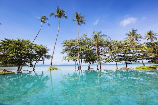 Een buitenzwembad, ligstoelen bij het zwembad