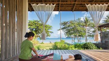 Guests can relax on the deck overlooking the ocean and tropical beach.