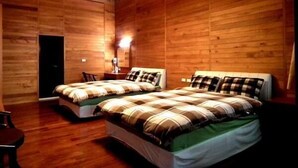 A wooden-paneled room with two beds, a desk, and a chair. - AiShangXiWeng B&B (Wufeng)