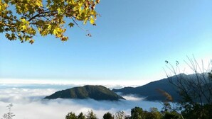 A mountainous landscape with a clear sky and forested areas. - AiShangXiWeng B&B (Wufeng)