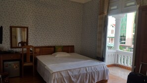 A bedroom with a bed, a desk, a chair, a mirror, and a balcony with a railing. - Dream Vinh Hoa (Bac Ninh)