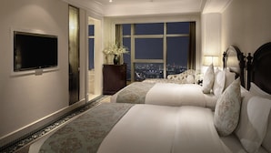 Une chambre d’hôtel avec un grand lit, une télévision et une vue sur la ville.