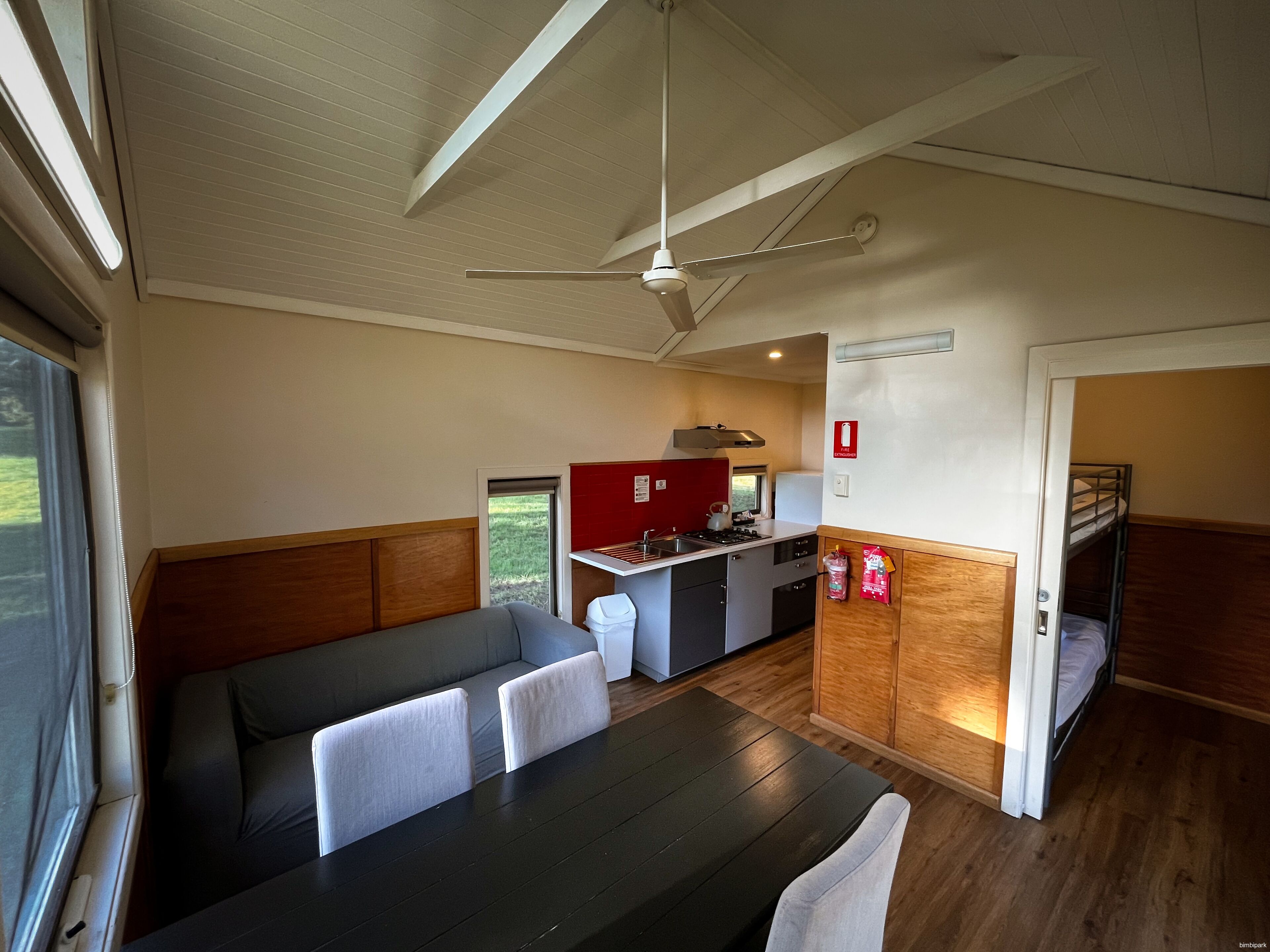 A compact room with a kitchenette, a dining table, and a seating area.