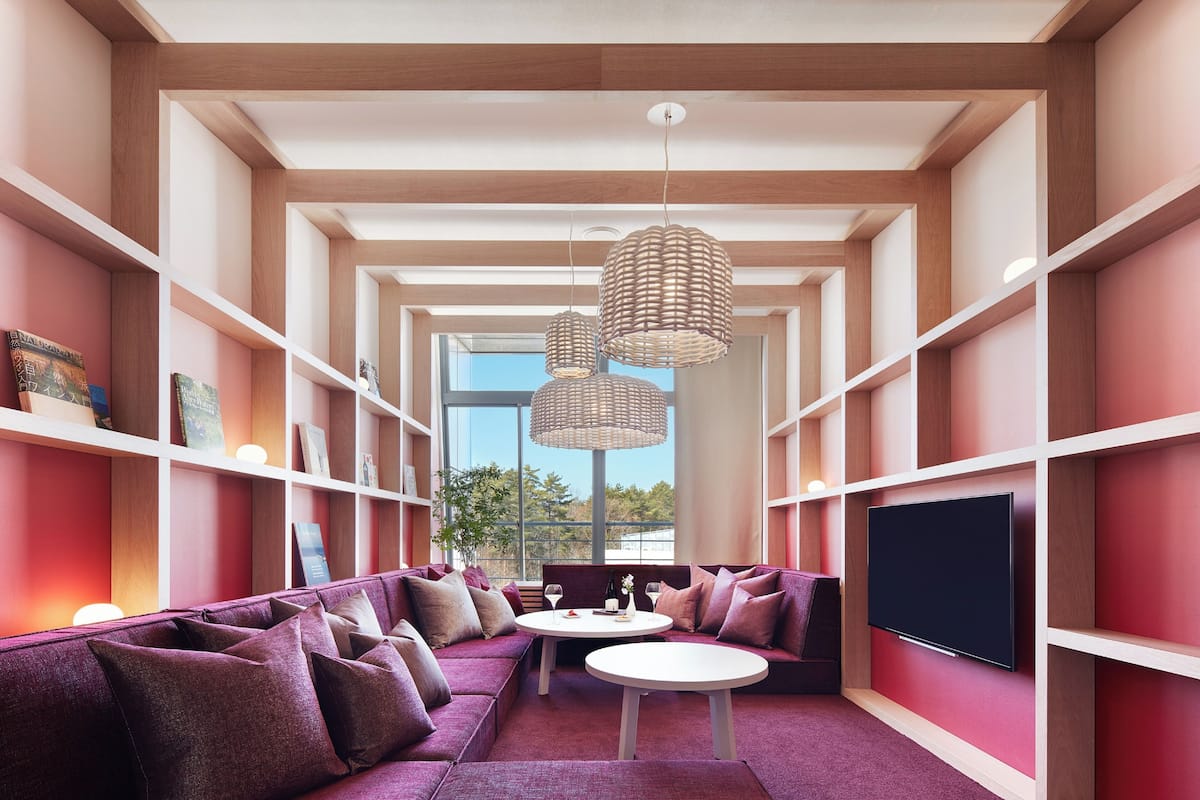 Una sala moderna con un sofá modular, un televisor de pantalla plana y una mesa de comedor.
