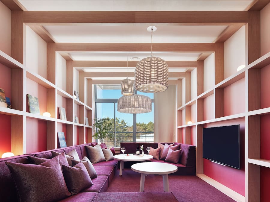 A modern living room with a sectional sofa, a flat-screen TV, and a dining table.