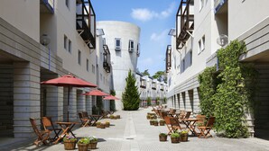A courtyard with outdoor seating, potted plants, and a central tower. - Hoshino Resorts RISONARE Yatsugatake (Hokuto)