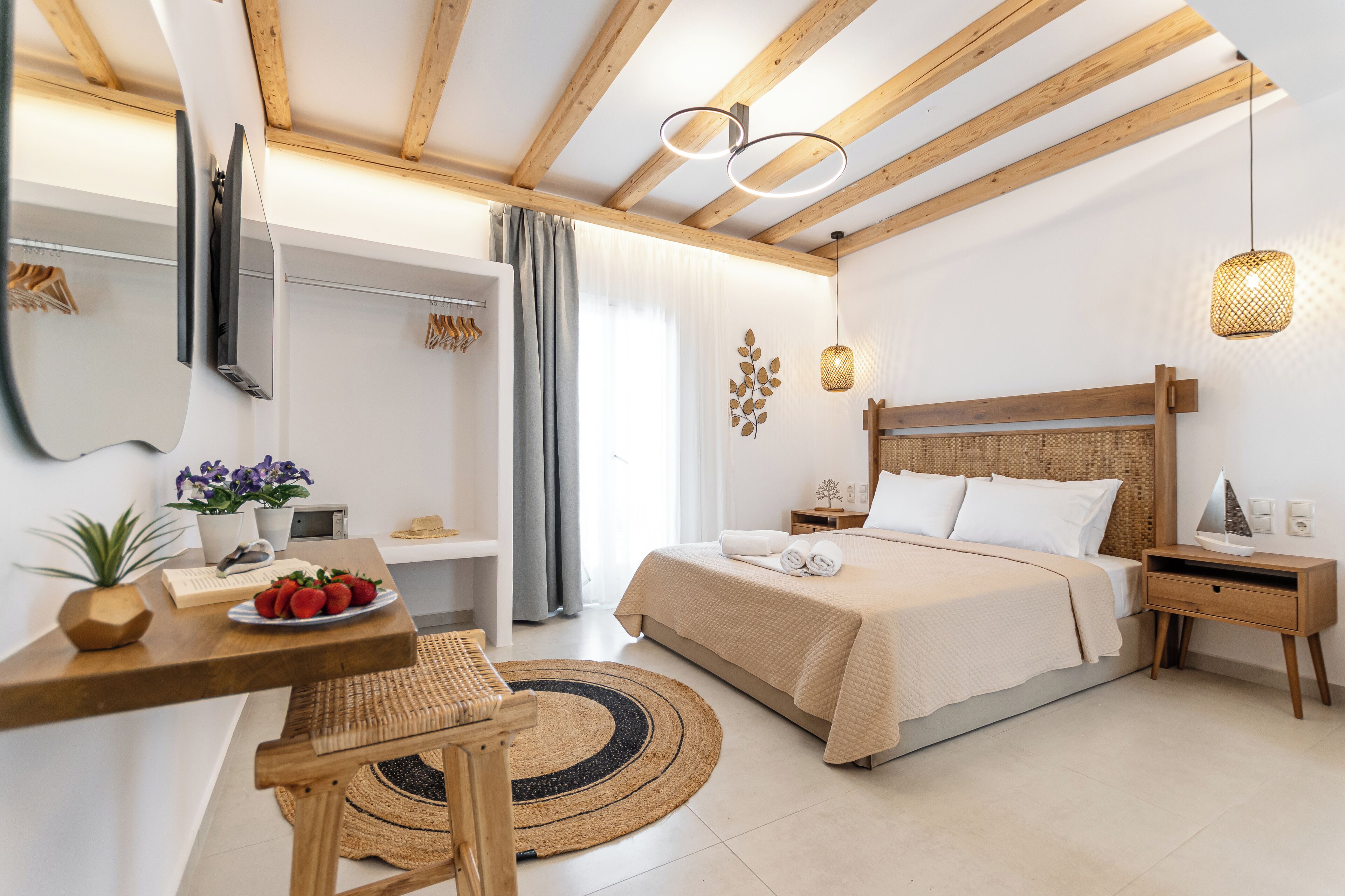Un dormitorio moderno con techo de madera, una cama con ropa de cama blanca, una mesita de noche con lámpara y una alfombra pequeña.