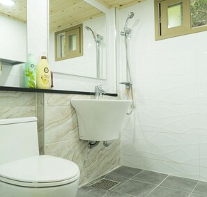 A bathroom with a toilet, a sink, and a shower.