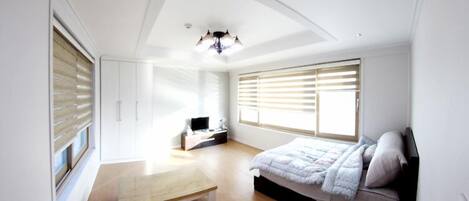Un dormitorio moderno con una cama, un escritorio y un banco.