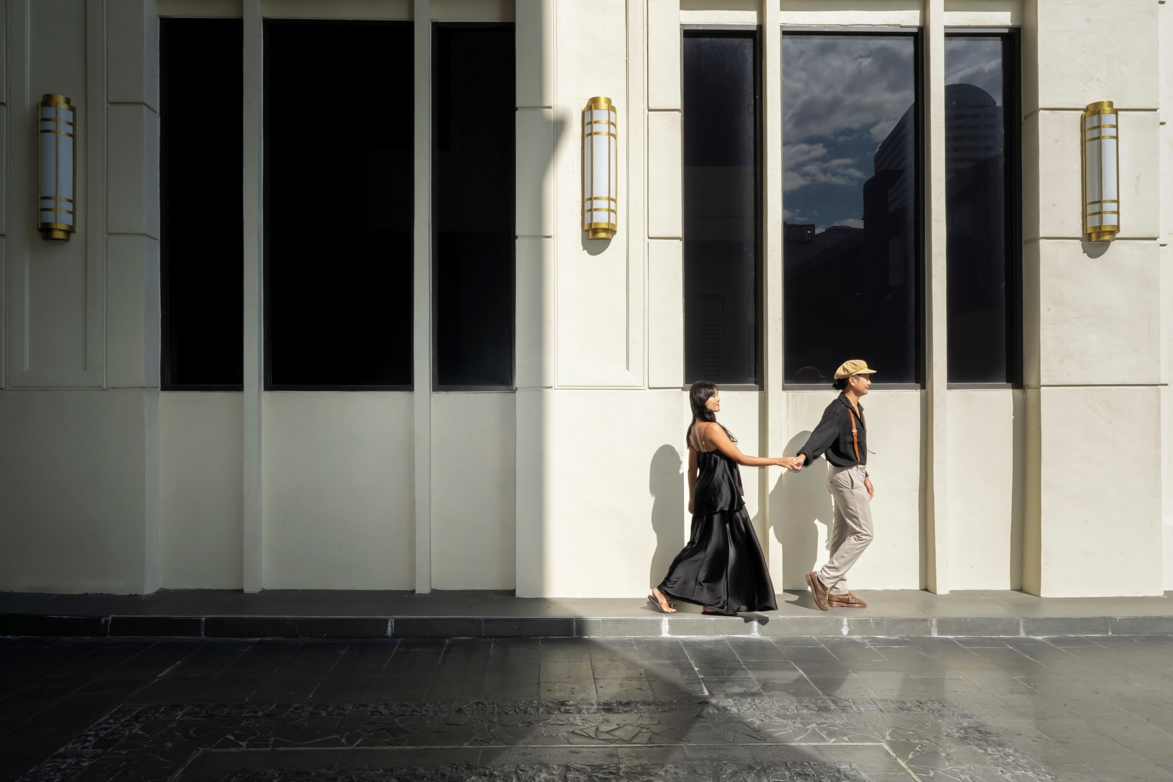 Une façade d’immeuble avec de grandes fenêtres et des luminaires fixés au mur.