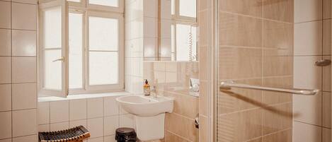 A bathroom with a toilet, sink, and window.