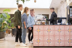 Een café met een bewerkt aanrecht, kamerplanten en een modern interieur.