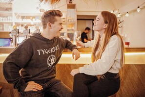 Un bar avec un comptoir et une personne assise.