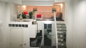 Un interior moderno con una escalera, una zona de estar con un cojín rojo y un letrero que dice "Carpe Diem".