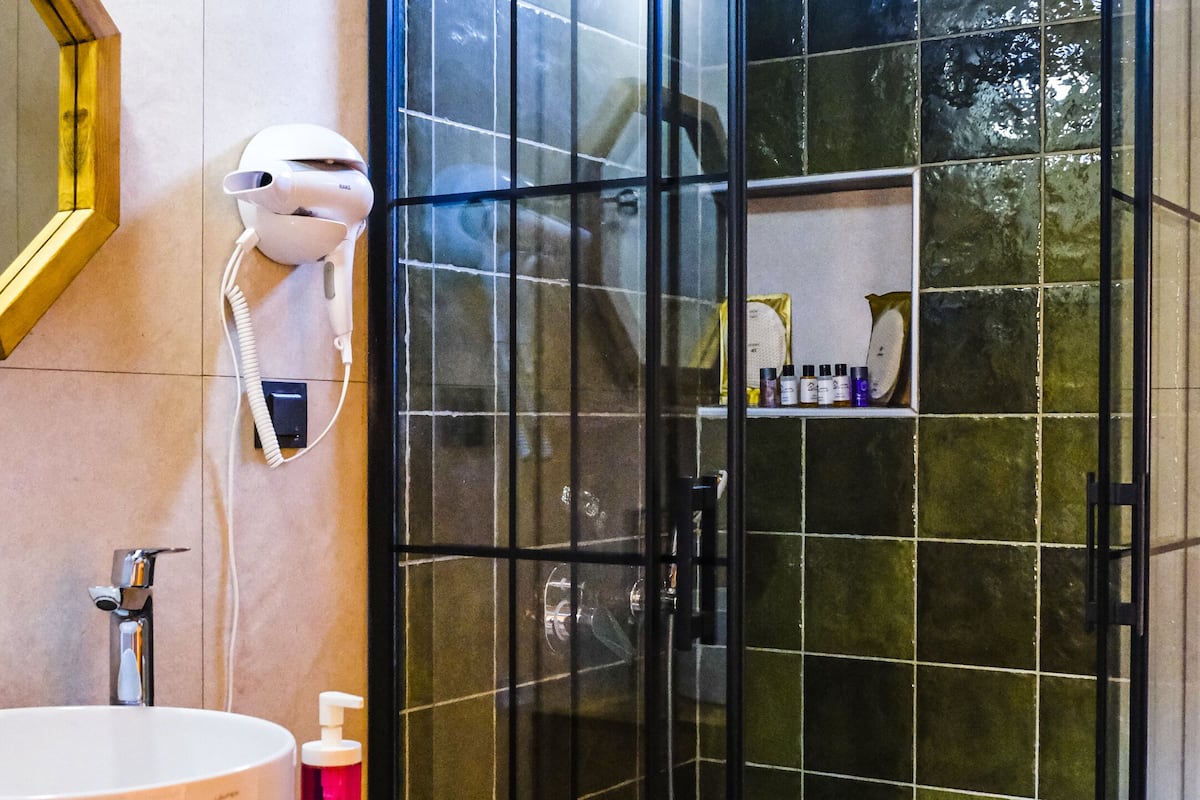 deluxe suite | bathroom | shower, free toiletries, hair dryer, slippers