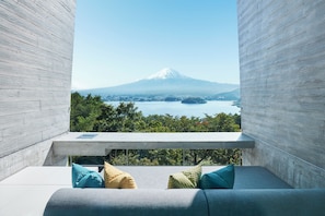 Un balcon avec vue sur une montagne et sur l’eau.