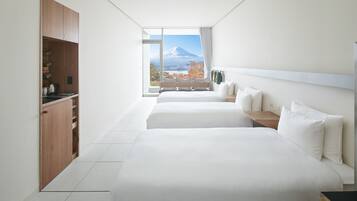 A modern hotel room with a large bed, a wooden wardrobe, and a view of a mountain.