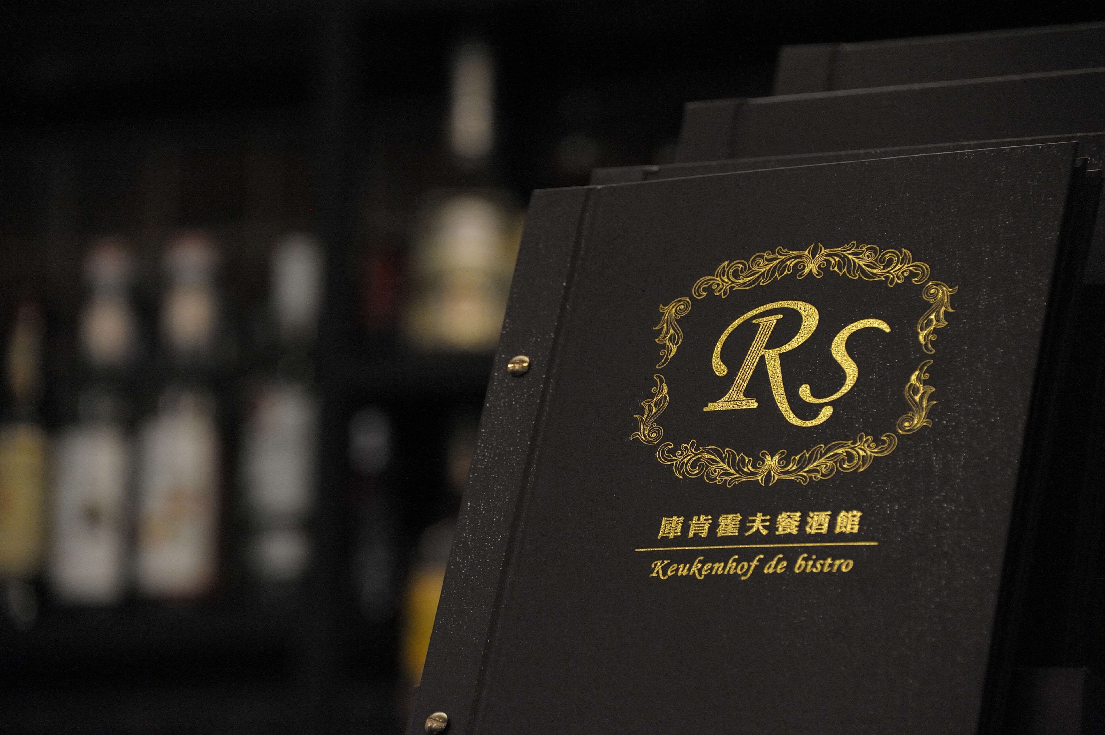 A black folder with a gold monogram and text in both Chinese and English.