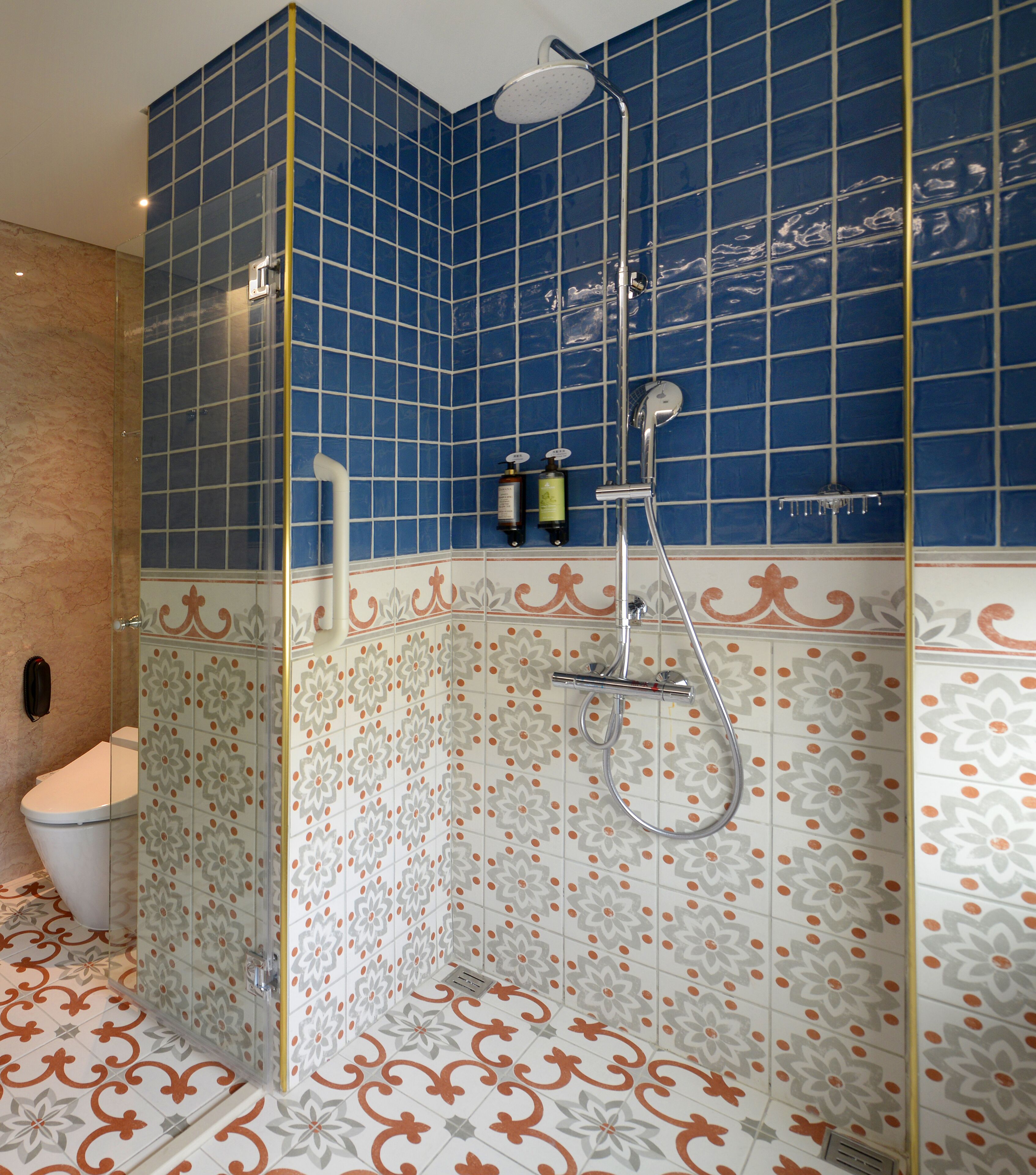 Un baño con ducha envuelta en vidrio, un inodoro y un lavamanos.