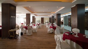A spacious banquet hall with white chairs and tables, wooden flooring, and a central aisle. - Raoum Inn Hotel Apartments- Buraydah (Buraydah)