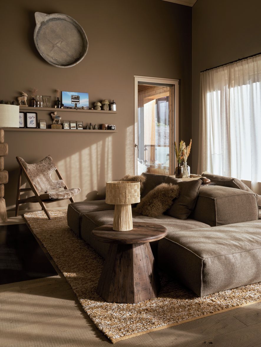 A modern living room with a sectional sofa, a wooden coffee table, and a decorative chair.