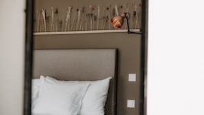 A bed with white linens, a headboard, and a bedside table with a lamp. - OVERLOOK Lodge by CERVO Zermatt (Zermatt)