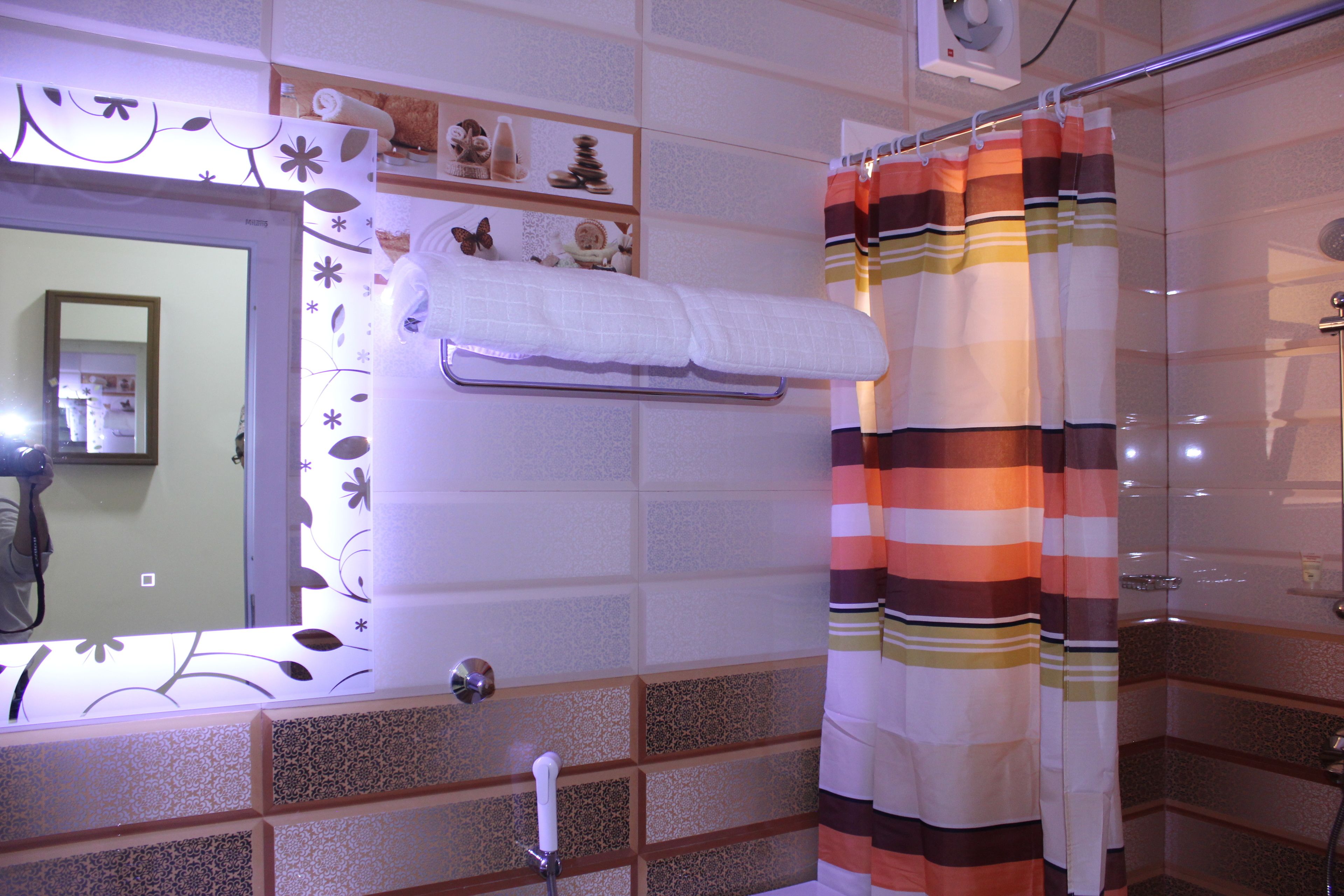 Un baño con cortina de ducha, toallero y espejo.