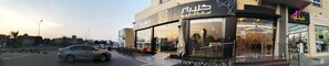 A coffee shop with outdoor seating and a modern storefront. - Sama Sohar Hotel Apartment (Sohar)